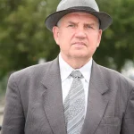 Home man wearing gray hat suit standing front tree tie has serious expression his face 449935804